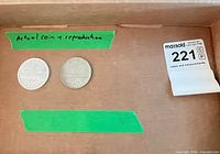 Two coins in box labelled actual coin and reproduction