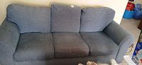 Front view of three-seat blue-grey sofa with loose back cushions