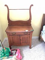 Full frontal view of wooden washstand showing backsplash, drawer, doors and legs