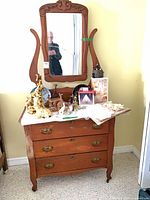 Front view of antique wooden washstand with mirror and brass handles
