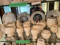 Front view showing vases, creamers, trinket boxes and plates