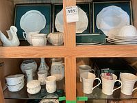 Cabinet view showing mugs, vases, swan, boxed plates