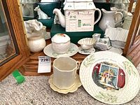 Group view of teapot, plate, cup, saucer, sugar bowl, creamer, figurines