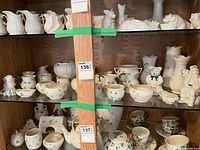 Overall view of two shelves showing Belleek porcelain pieces