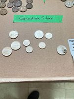 Top-down view of nine Canadian silver coins under tape label 'Canadian Silver'
