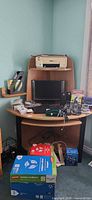Full view of corner desk loaded with electronics and paper reams