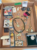 Overall view of box containing assorted costume jewelry pieces
