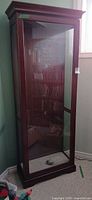 Full view of wooden curio cabinet showing glass panels and overall condition