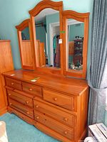Full view of wooden dresser with tri-fold mirror attached