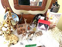 overview of all figurines, plates, candle holder box and linens on dresser