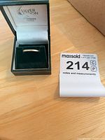 Ring in open display box on tabletop beside lot tag