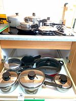 Overview of pots and pans on stovetop and drawer