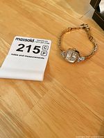 Overall view of gold-filled watch on bracelet with MaxSold tag visible