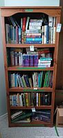 Front view of tall wood bookcase filled with books (books not included)