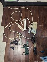 Four power strips and four extension cords laid out on floor