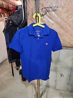Front view of blue polo shirt on hanger