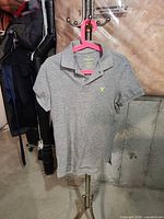 Front view of gray polo shirt on hanger
