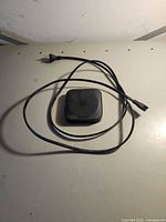 Apple TV box with power cord shown on table