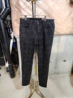 Full view front of black patterned jeans on hanger
