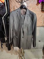 Front view of gray pinstripe suit jacket with trousers on hanger