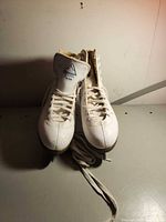 Front view of both white Glacier 120 figure skates with laces