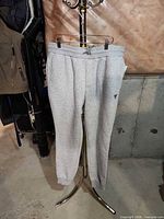 Front view of Guess sweatpants hanging, showing waistband and cuffs