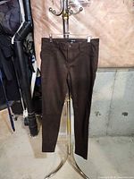 Front view of brown Harlow skinny jeans on hanger