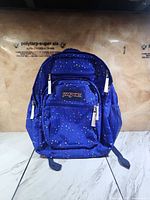 Front view of JanSport backpack showing star pattern and pockets