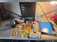 Overview of shredder, writing instruments, tape, stapler, notebook, office sundries