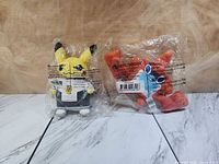 Both sealed plush toys side by side in original packaging