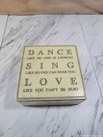 Top view showing lid with printed inspirational phrases and cream marble surface