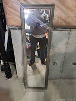 Front view of tall rectangular mirror with distressed wood frame