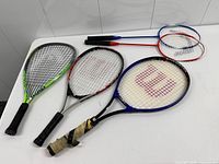 Five racquets laid out showing fronts
