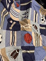Full view of quilt showing multiple sports appliqués and color blocks