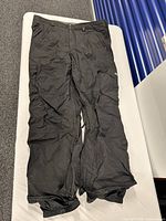Full view of black Burton ski/snowboard pants laid flat
