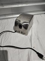 Overall view of stainless steel EnBath hand dryer with cord