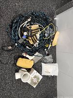 pile of cords, gloves, sponges, PVC coupler, booklet