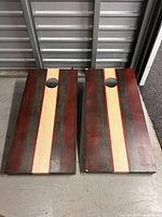Two striped wood cornhole boards side by side