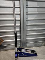 Full view of floor jack standing upright with handle attached