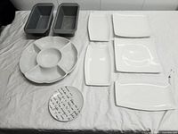 Group shot showing all loaf pans and plates laid out on cloth