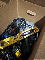 Box interior showing Stabila spirit level, cordless drill, battery pack, corded drill and cords