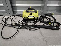 Ryobi 1800 PSI pressure washer with hoses and spray gun laid out
