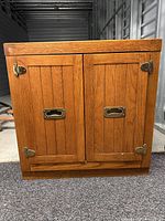 Front view of the wood cabinet showing doors and hardware
