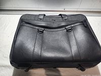 Top view showing overall briefcase, handles, front pocket, rolling base edges