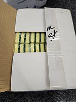 Open carton showing sealed packs of yellow-green scrubbing sponges