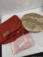 All items laid out: folded tablecloth, stack of gold placemats, sealed towel pack