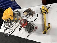 View of Wagner paint sprayer, two sanders and work light on table