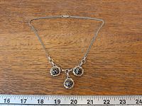 Full view of necklace showing chain and three rose pendants