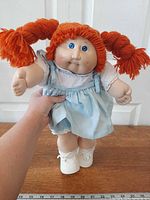 Full view of doll standing showing hair, face, outfit, shoes