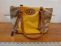 Front view of Franco Sarto beige and mustard yellow tote showing straps, hardware and ruler for scale
